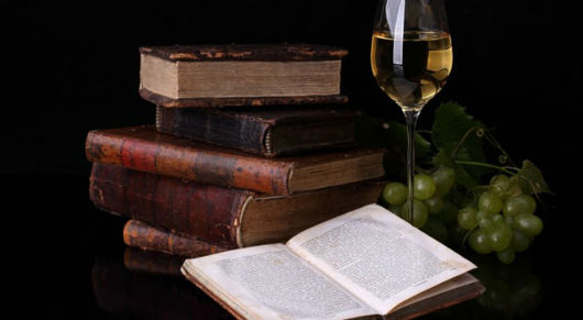 Feed old books glass of wine and grapes 730x400